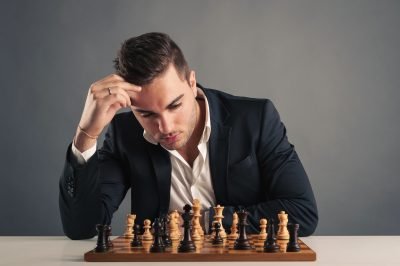 Man playing chess, isolated on dark background.